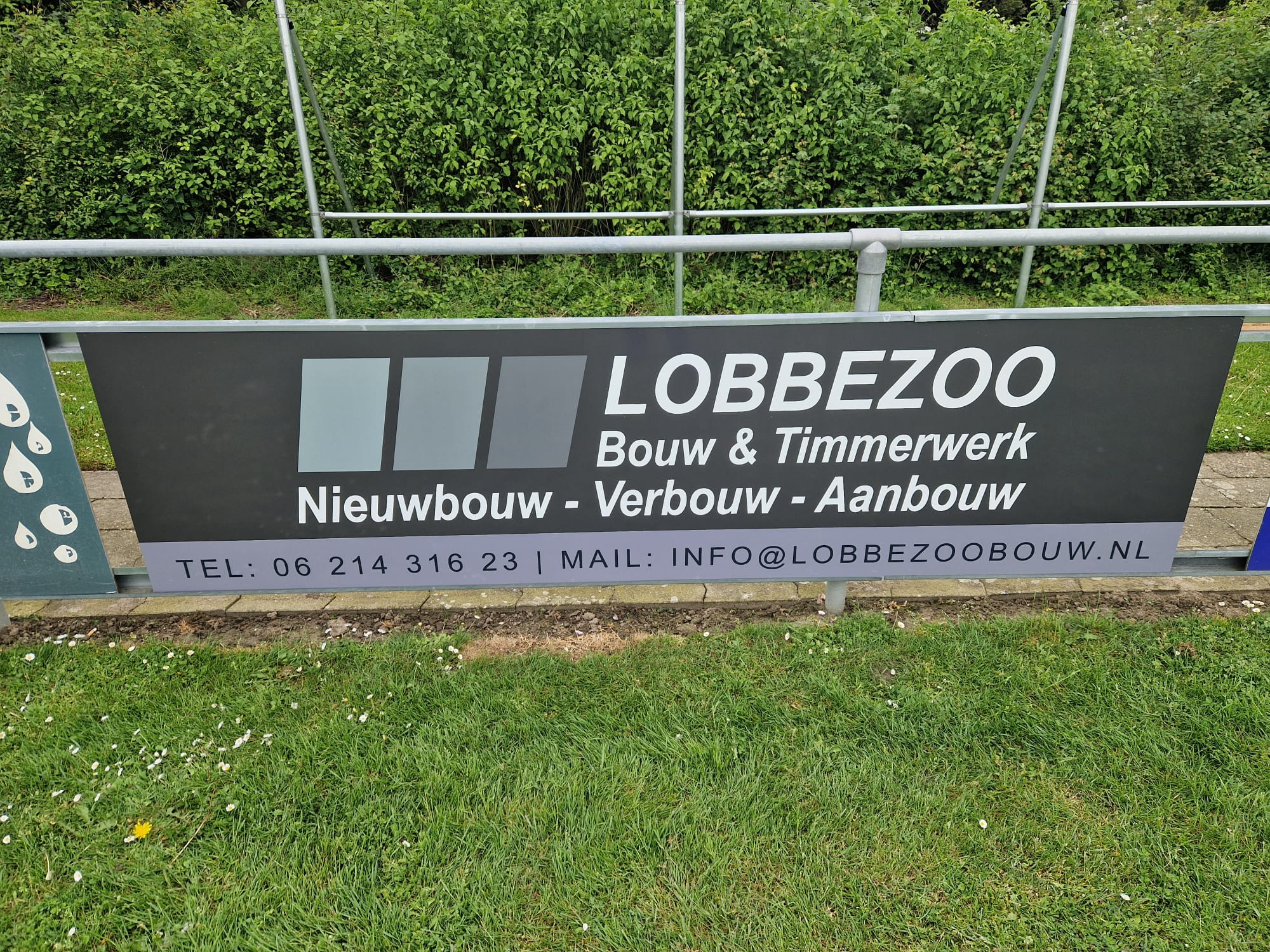 sponsorbord langs voetbalveld met reclame van lobbezoo bouw en timmerwerk