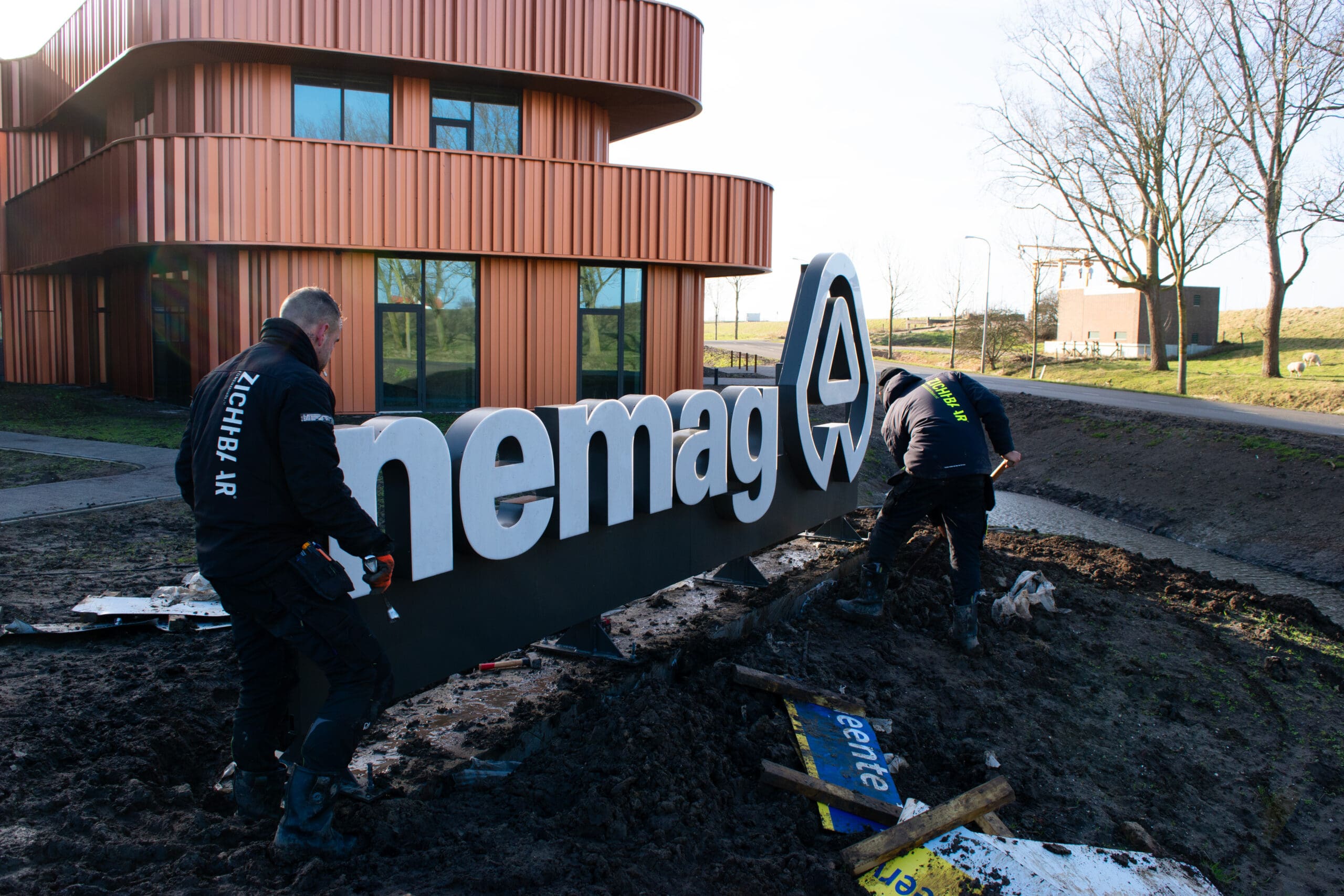 monteurs bezig met de montage van verlichte doosletters bij nemag