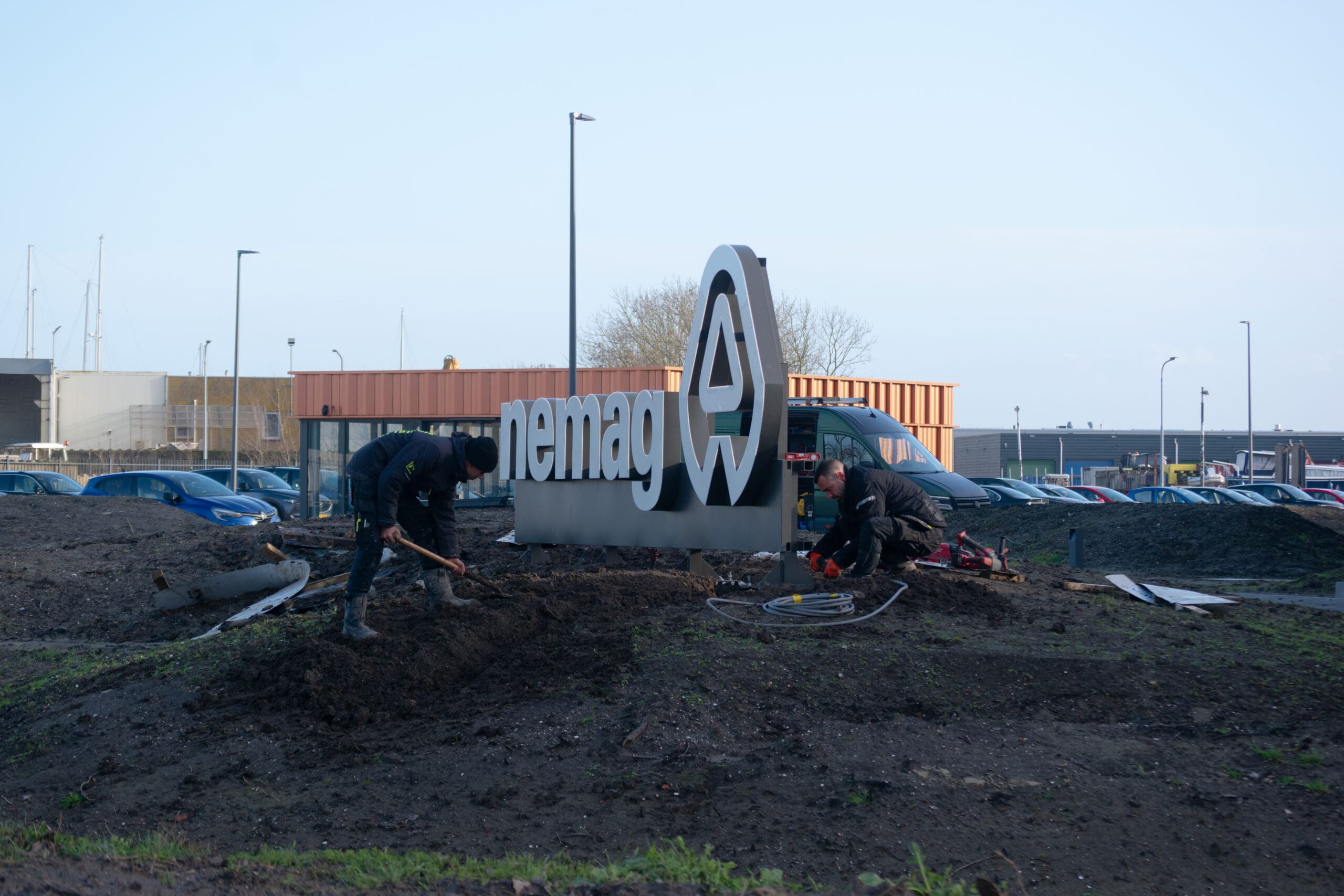 monteurs bezig met de installatie van verlichte reclame bij nemag