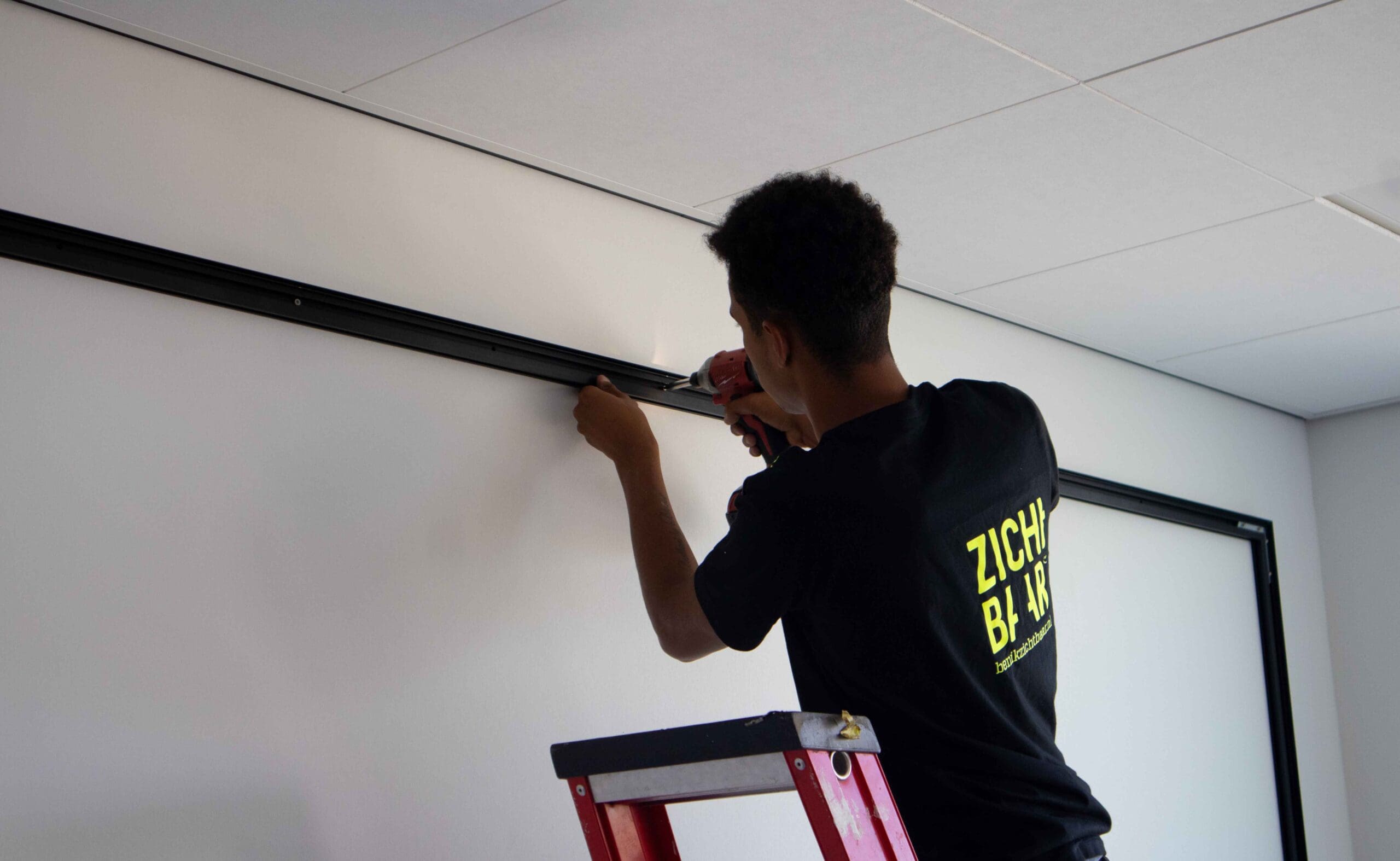 montage van textielframe in een kantoorruimte
