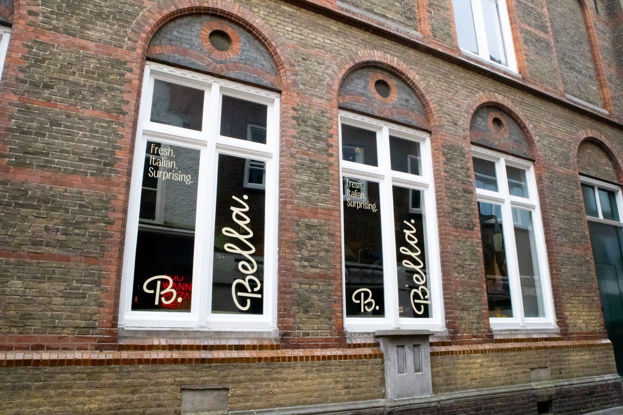 raamstickers met logo bevestigd aan de zijkant van een restaurant