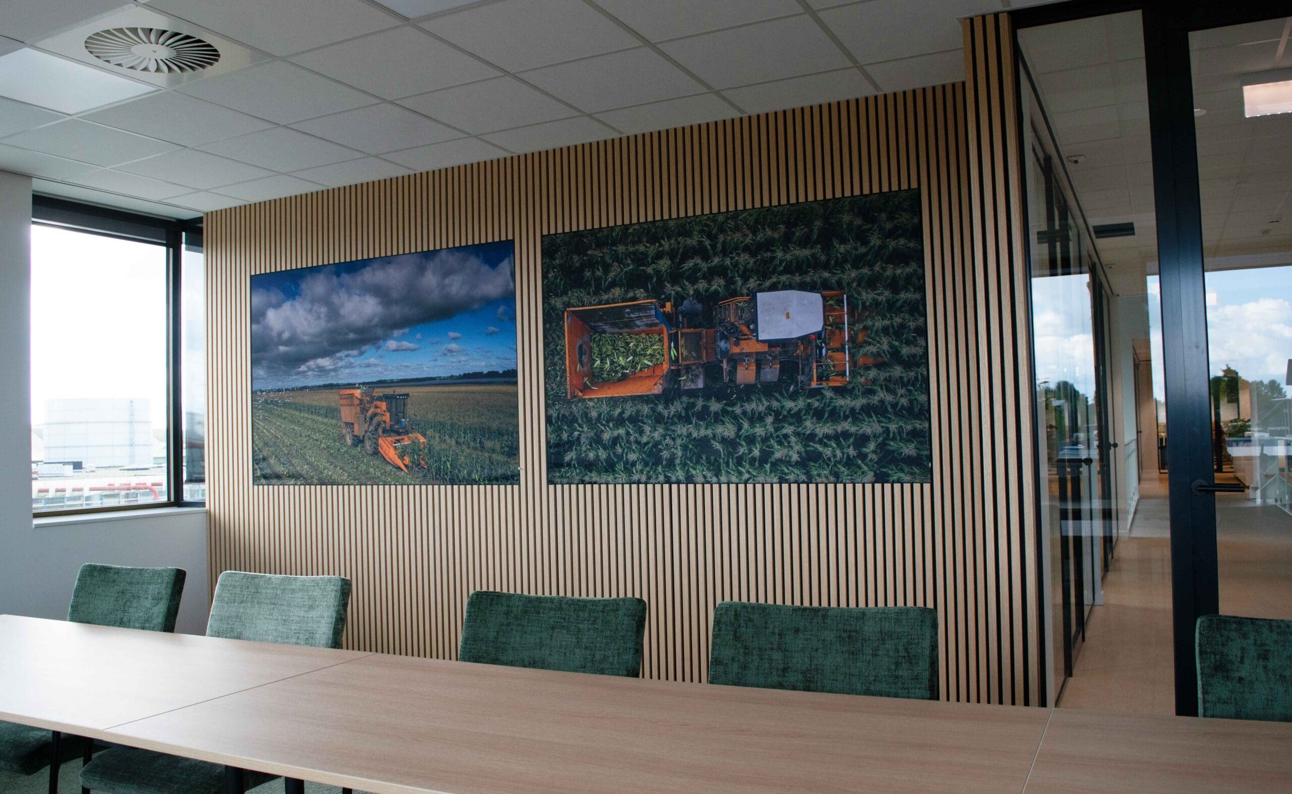 twee textielframes met foto aangebracht in een vergaderruimte